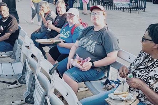 a group of pathfinders sitting at a baseball game, enjoying refreshments