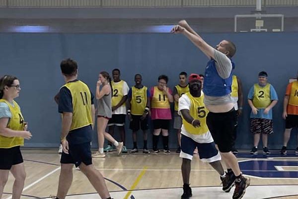 pathfinders playing basketball, and one player going for a jumpshot